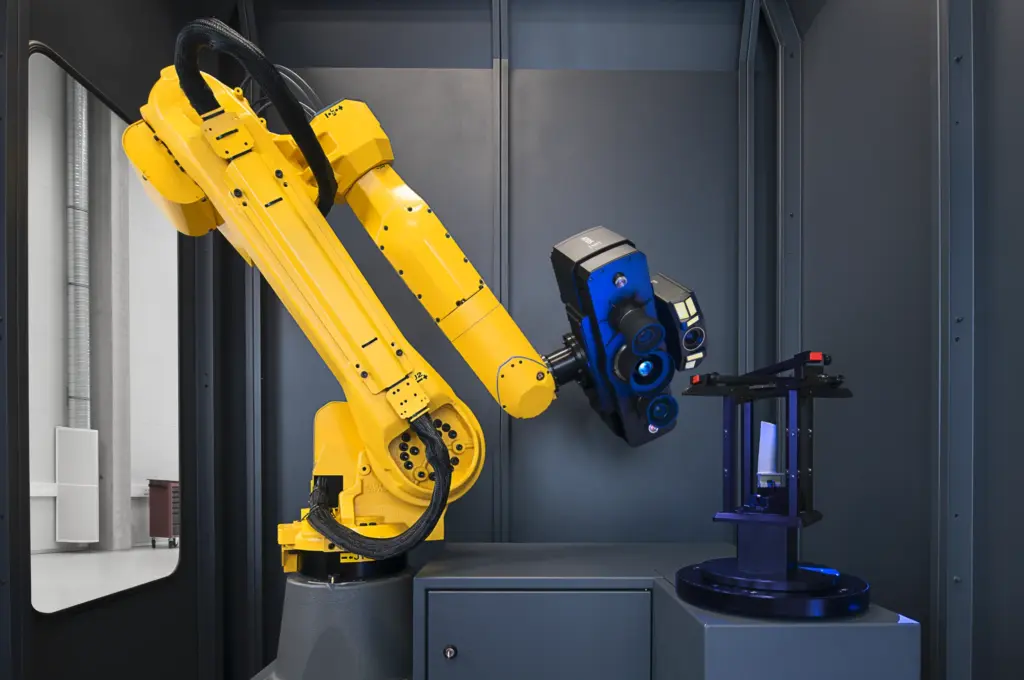 ZEISS ATOS 5 for Airfoil mounted on a yellow robot arm beside a blade fixture inside a measuring cell