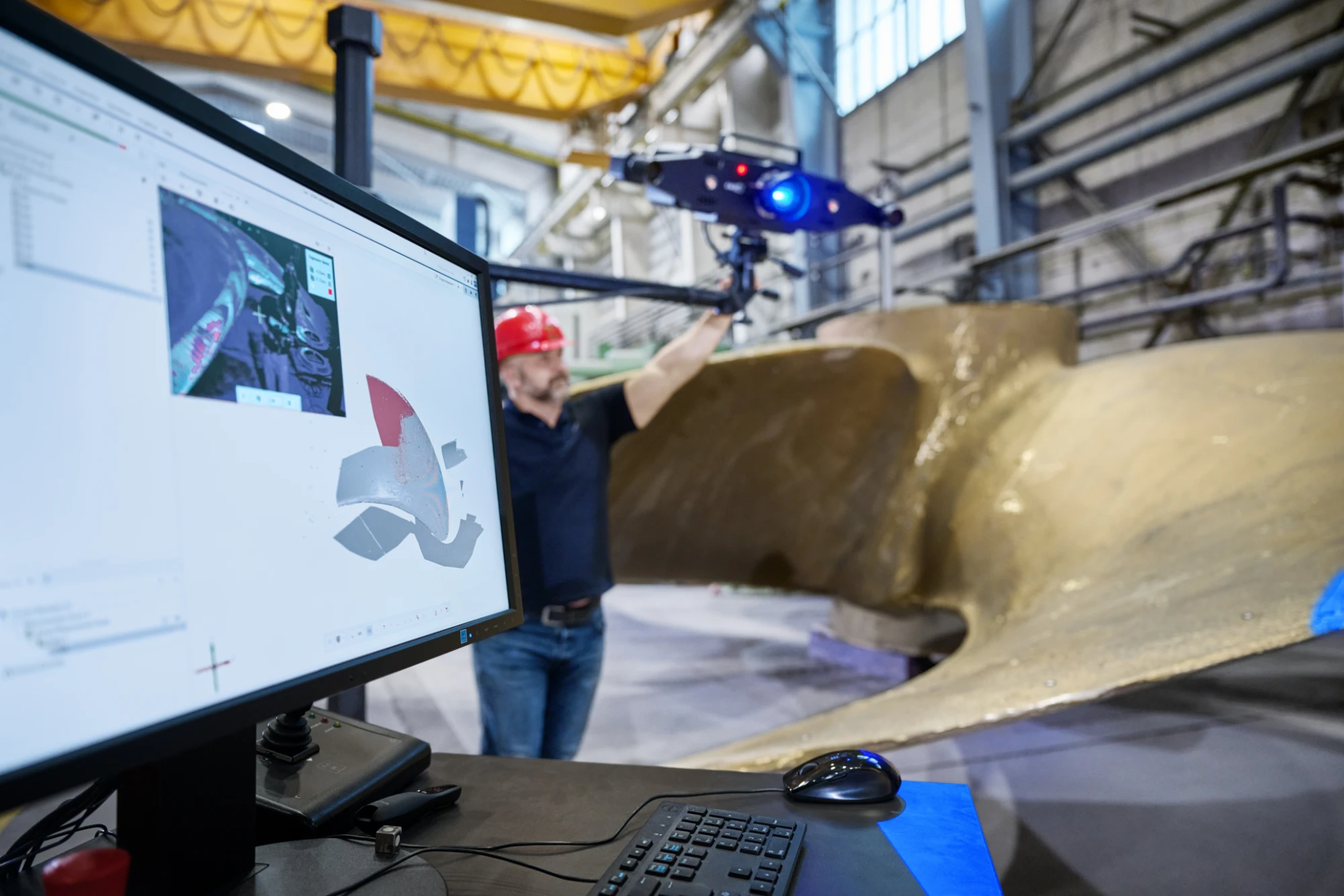 ZEISS ATOS LRX scanning a large cast ship propeller blade, with the captured mesh on the operator screen