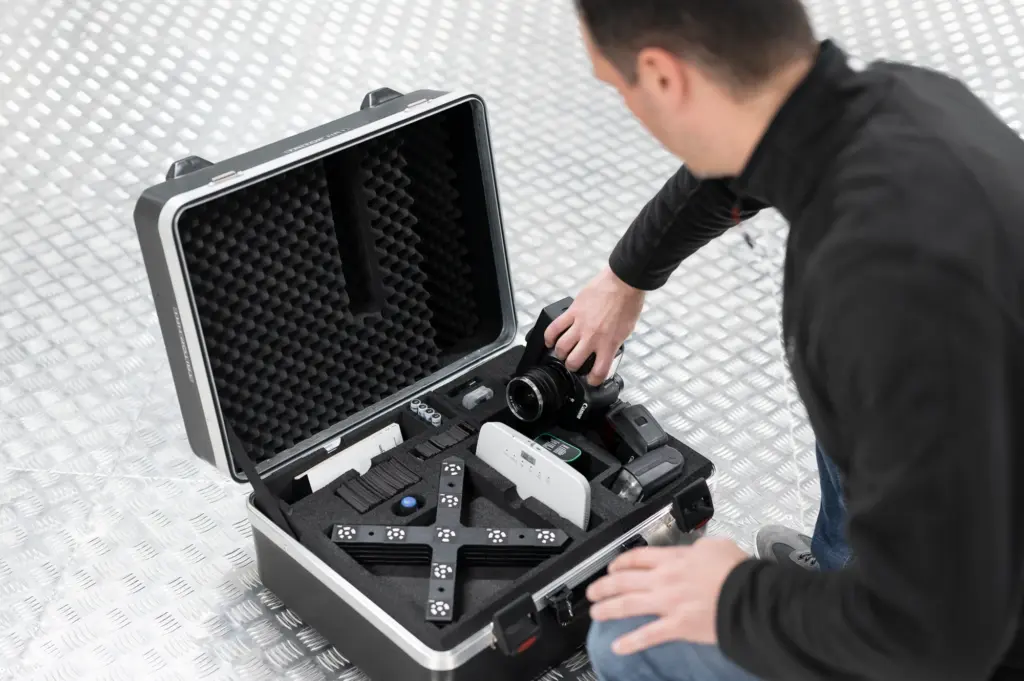 Engineer lifting the camera out of a ZEISS TRITOP case packed with reference crosses and scale bars