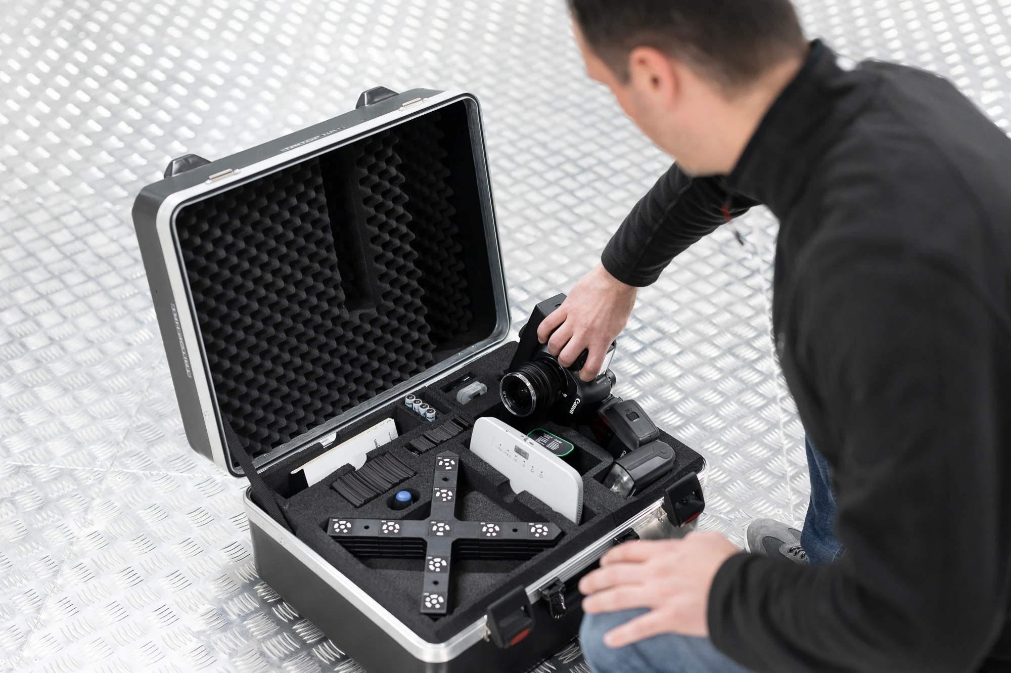 Engineer lifting the camera out of a ZEISS TRITOP case packed with reference crosses and scale bars