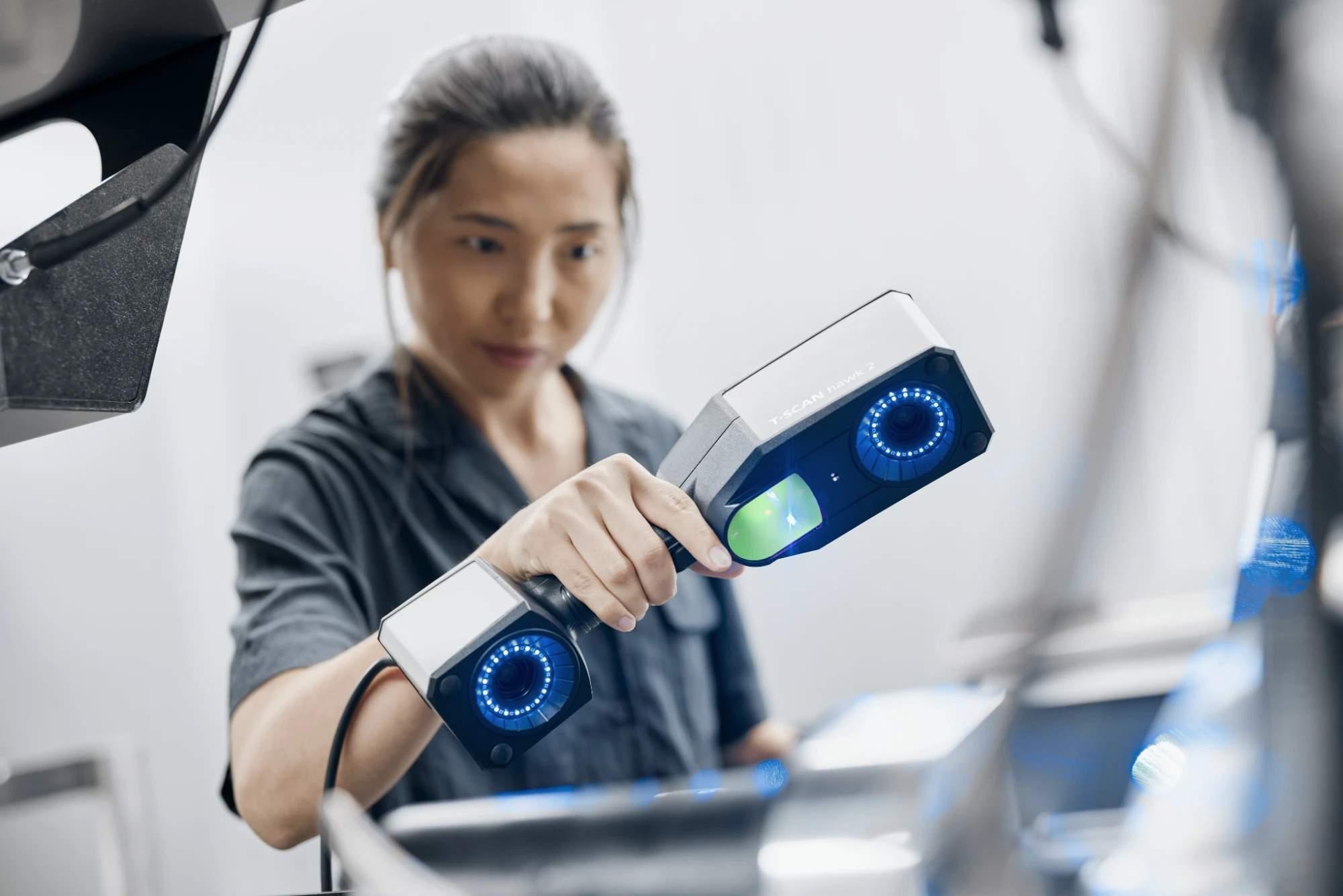 Engineer inspecting a part with a handheld ZEISS T-SCAN hawk 2 laser scanner
