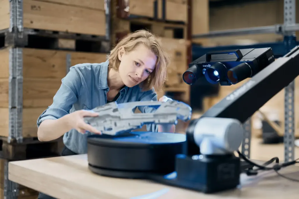 Operator placing a metal casting on the turntable of a ZEISS ScanPort scanning station