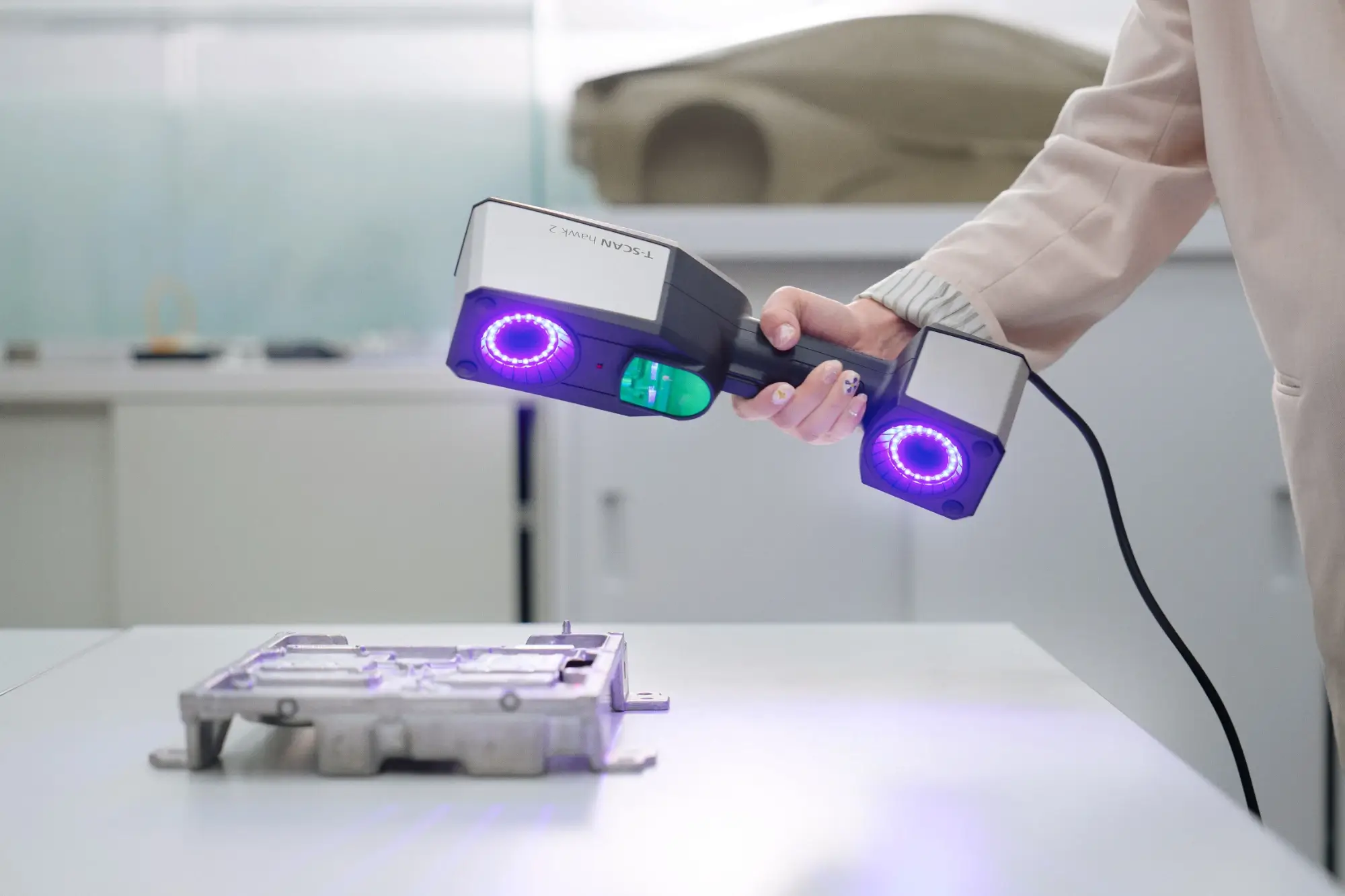 Handheld ZEISS T-SCAN hawk 2 scanning an aluminium die-cast housing in a design studio